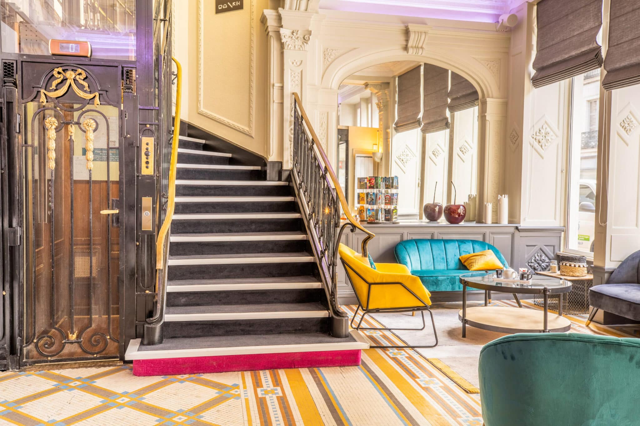 Hall d'accueil chaleureux et lumineux avec ascenseur et accès escalier de l'hôtel ibis Blois par ACP Hospitality.
